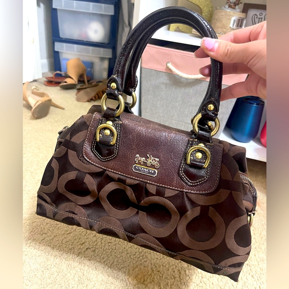 Brown Coach purse with gold accents worn